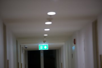 Un couloir d'un centre hospitalier éclairé par l'éclairage de sécurité pour donner le sens de l'évacuation